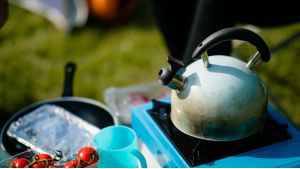 Camping kettle and cooking essentials on a portable stove at Monkey Tree Holiday Park’s self-catering pitch area