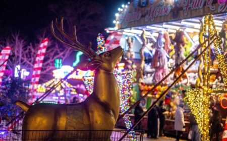 A statue of a stag in front of carnival games at Winter Wonderland Cornwall